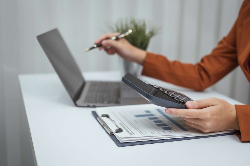 Close up hands of woman in brown formal suit checking Roth IRA