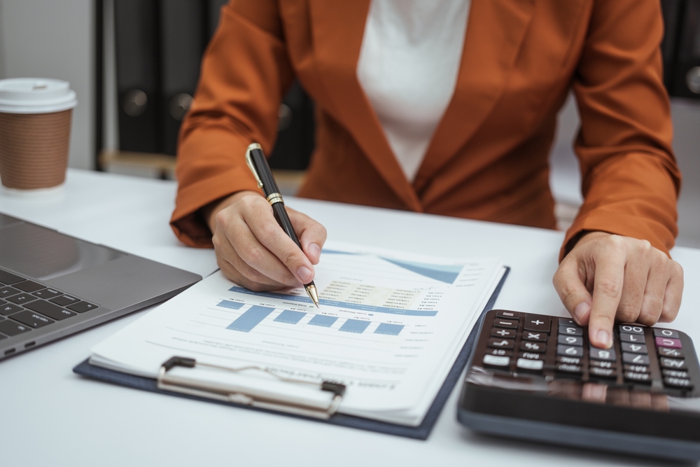 Close up hands of woman in brown formal suit checking Roth IRA